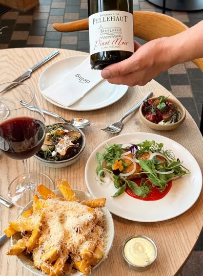 Red wine, french fries and salad on the table